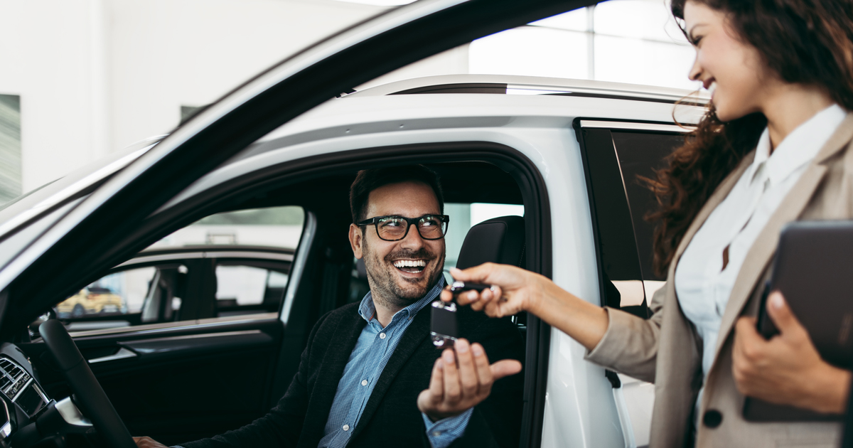 Man in rental car takes keys from an agent