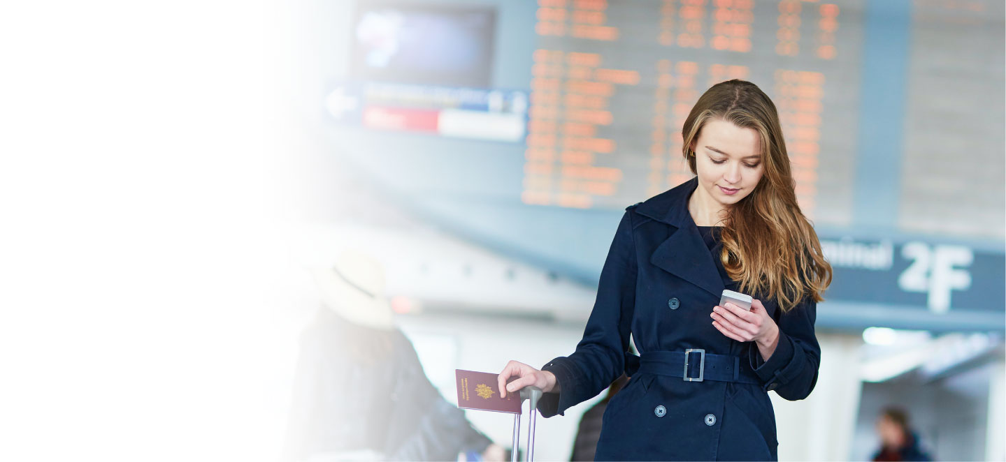 woman looking at phone in airport terminal